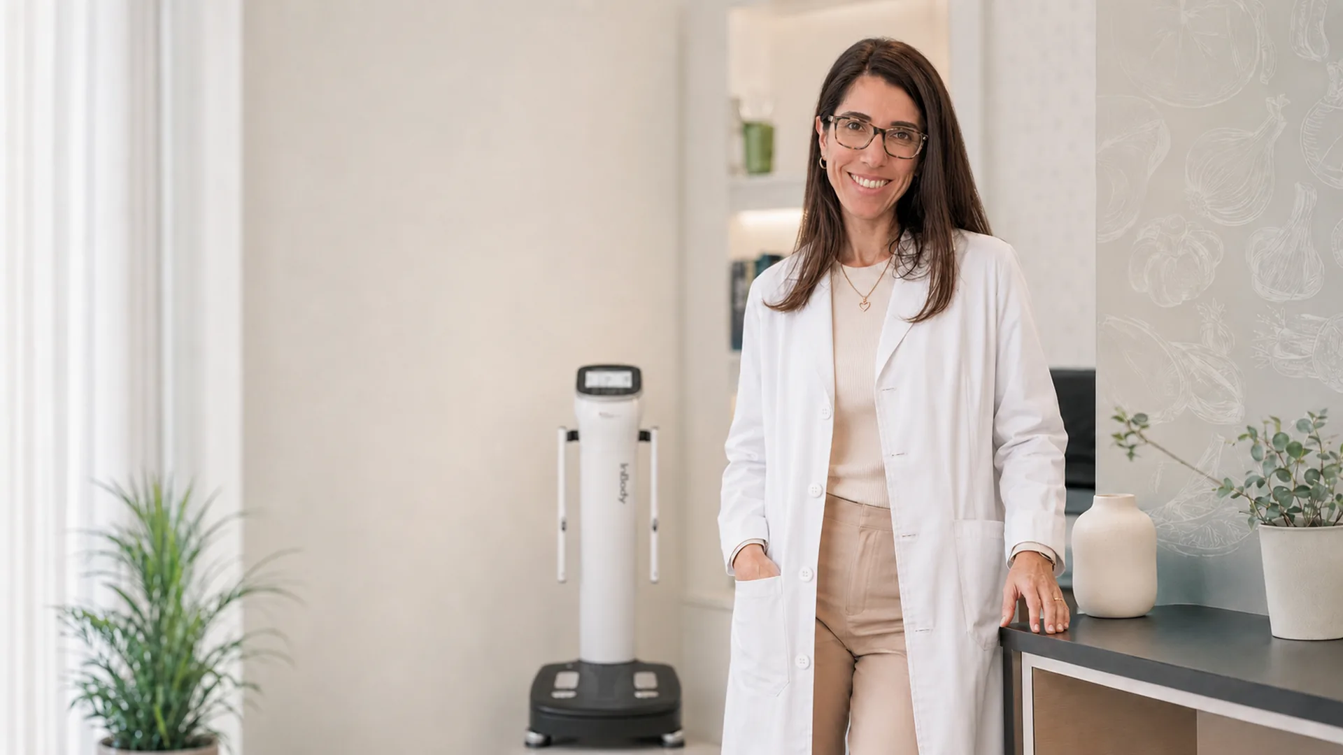 Dra. Catarina Cachão Bragadeste no consultório, junto à bioimpedância multipolar InBody 970.