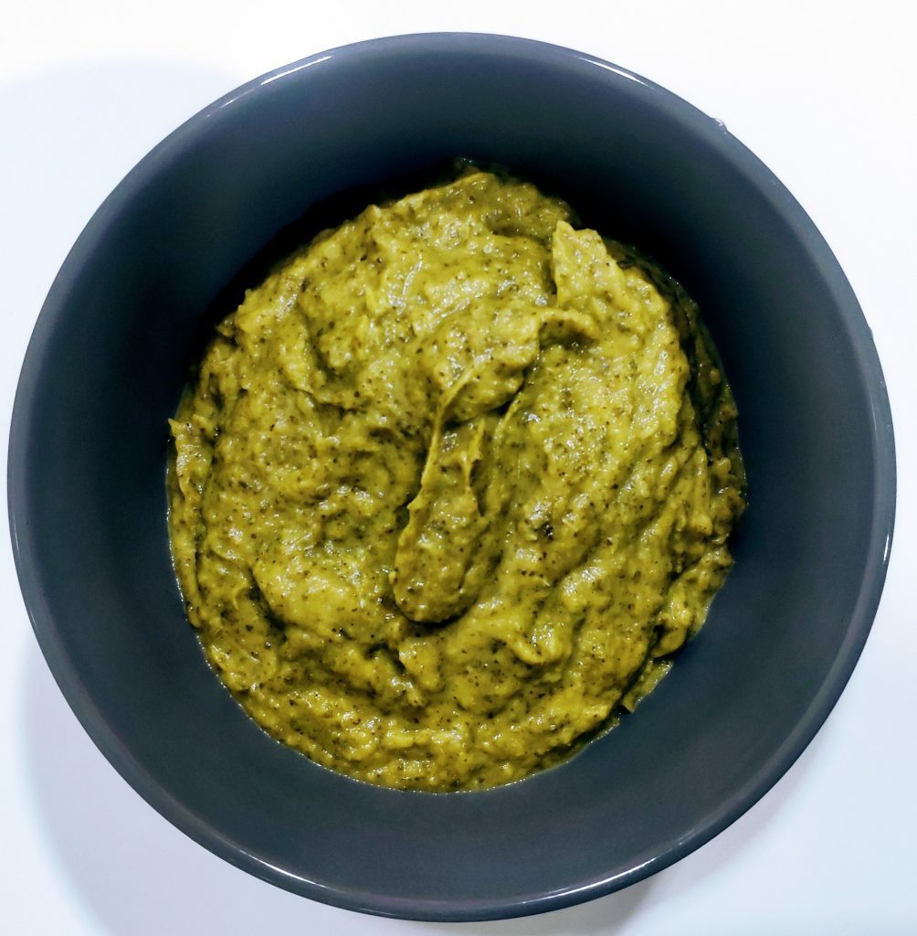 Pasta de grão-de-bico com ervas frescas e alho, pronta para untar pão ou usar como molho saudável em refeições