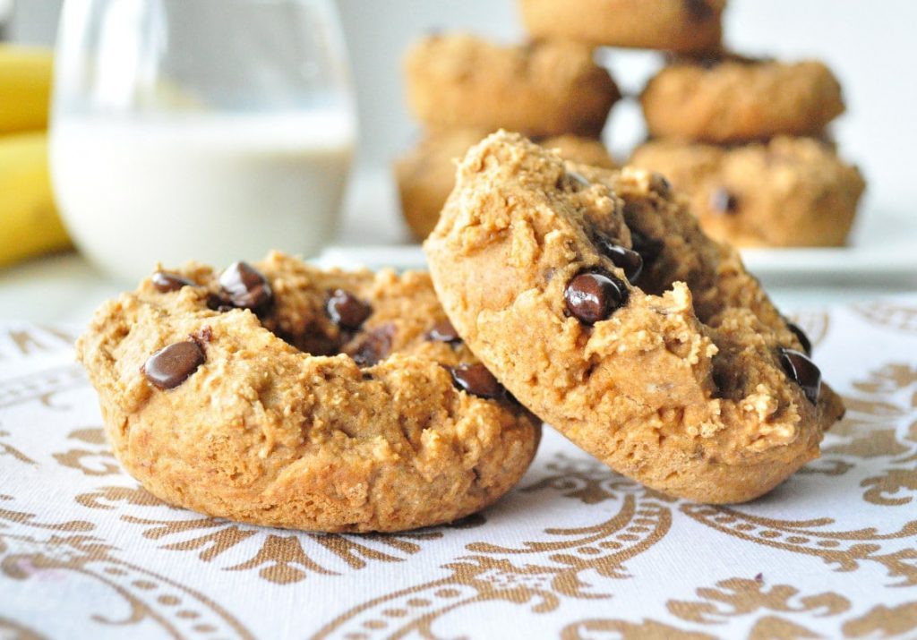 Mini bolachas de aveia com gotas de chocolate e banana, acompanhadas de leite, num cenário de pequeno-almoço saudável